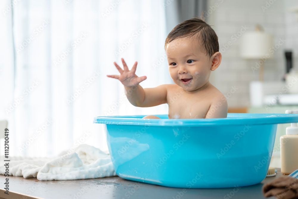 Asian baby taking a bath in a blue tub at home. Asian baby taking a bath in a blue tub at home.
