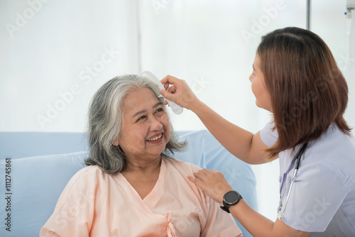 Asian female nurse combing hair of senior woman at the hospital ward