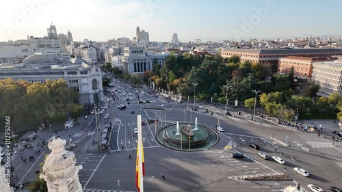 View of Palacio de Cibeles in Madrid on a sunny day, featuring historic architecture, traffic, and a vibrant urban setting.
