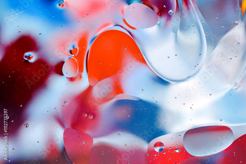 Close-up of the movement of oil droplets on the water surface. Colorful abstract macro background of oil drops on the water surface.