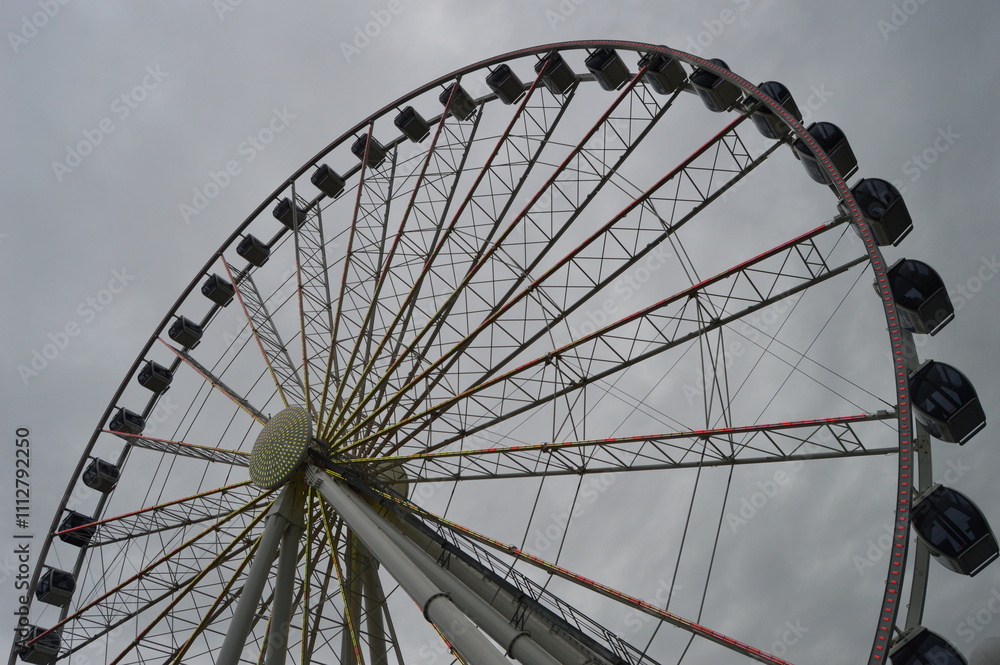 Fototapeta premium Ferris Wheel Against Dramatic Sky with Geometric Pattern