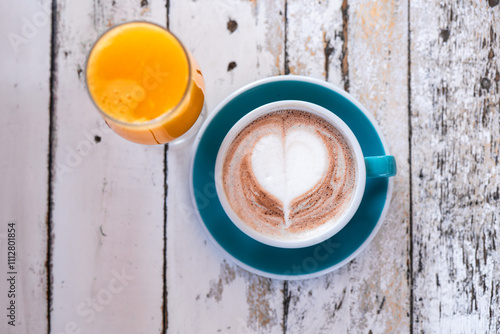 Cozy latte art and fresh orange juice on rustic table setting photo