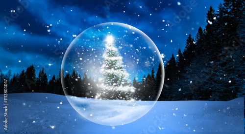 Gläserne Weihnachtskugel vor verschneitem Winterwald