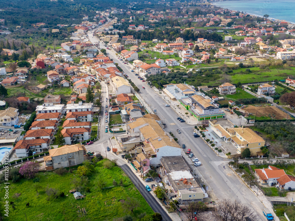 Aerial view of a coastal town with houses, roads, and green spaces. Aerial view of a coastal town with houses, roads, and green spaces.
