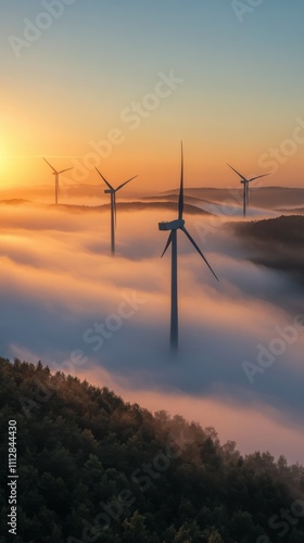 Wind turbines generate renewable energy at sunrise in a misty landscape