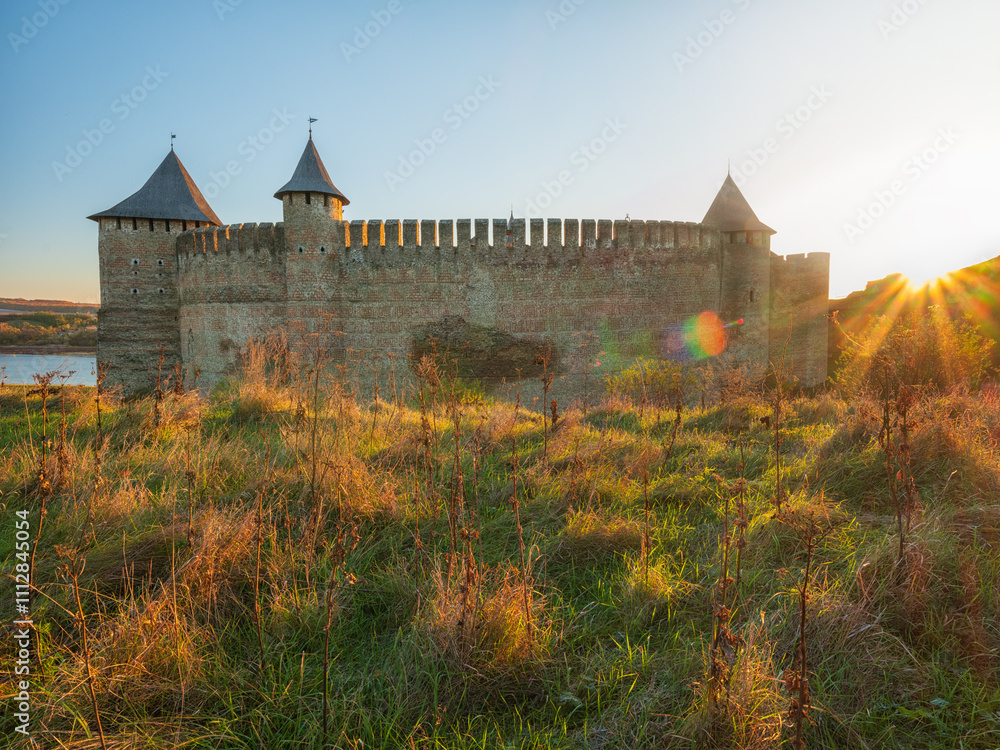 view to facade of old fortress in autumn morning and sun glare on walls view to facade of old fortress in autumn morning and sun glare on walls