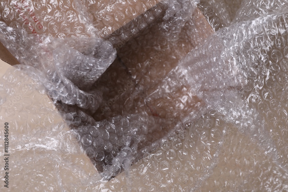 Empty cardboard box with bubble wrap on table, closeup Empty cardboard box with bubble wrap on table, closeup