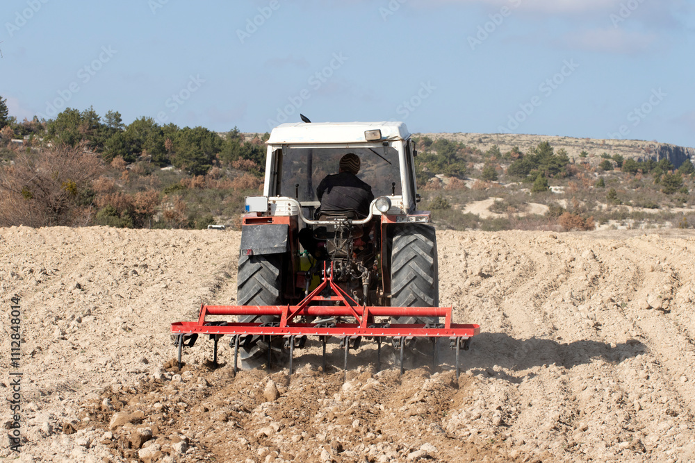 A tractor ploughing a crop field for planting in late November