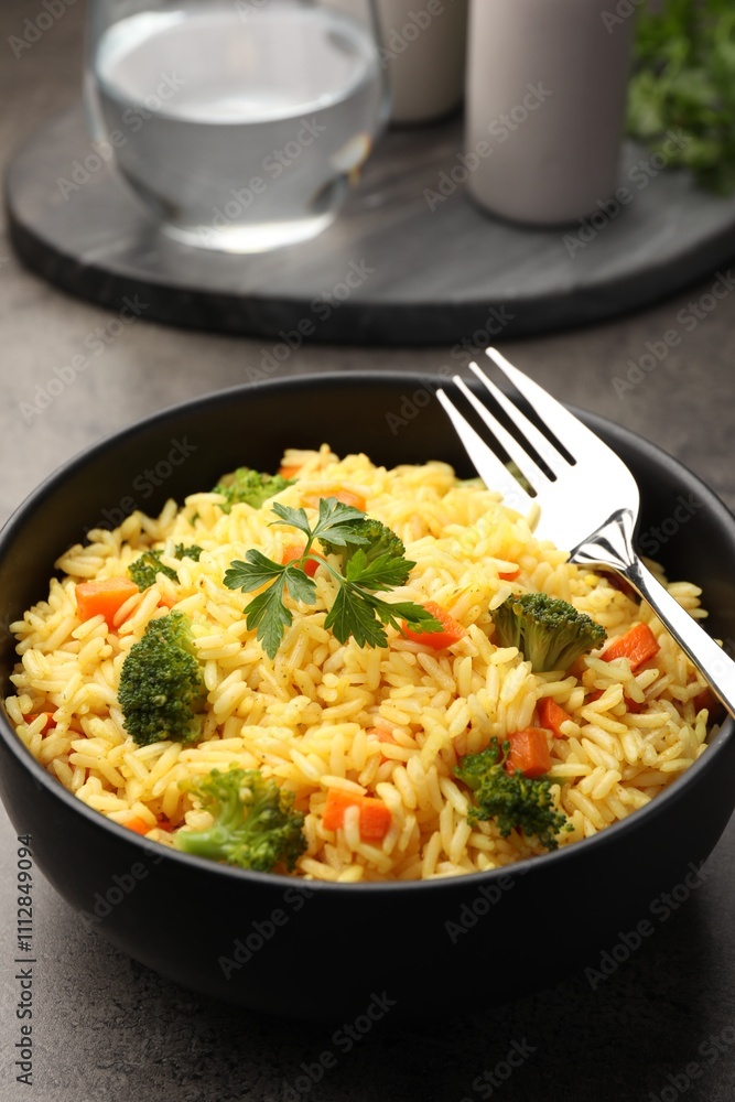 Tasty rice with vegetables on grey table, closeup Tasty rice with vegetables on grey table, closeup