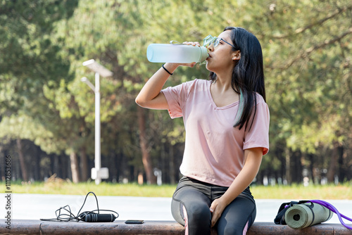 Athlete hydrates during a break from her outdoor exercise routine photo