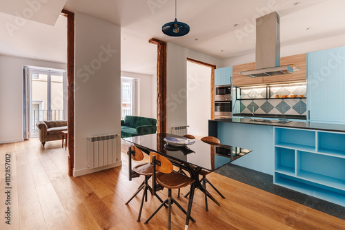 A modern open-plan kitchen and dining area with a blue kitchen island photo