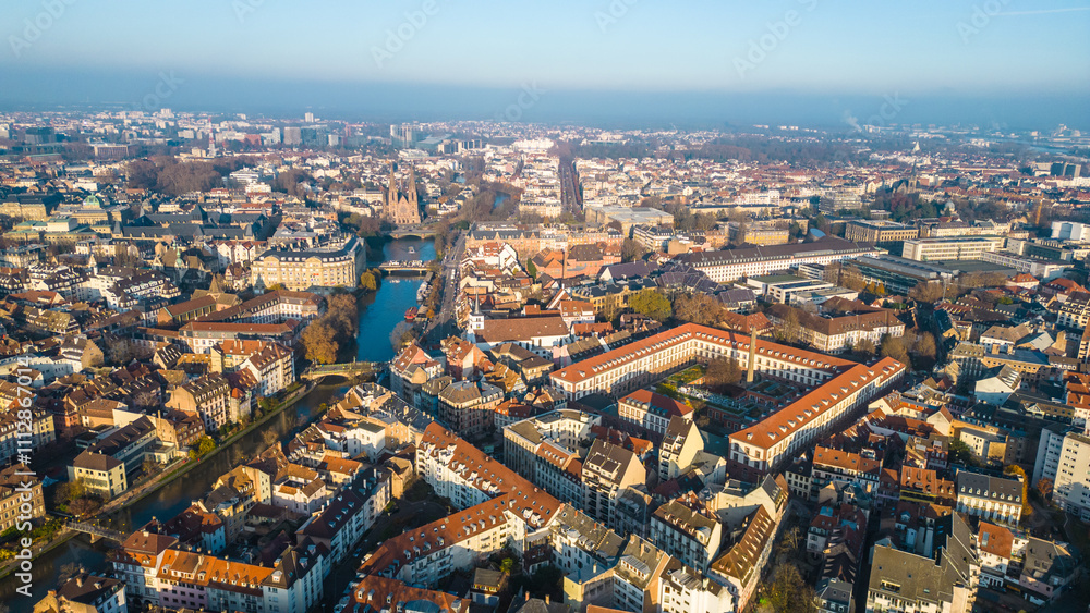 Fototapeta premium Strasbourg, the capital of Christmas, sparkles during Advent, with its stunning decorations and festive ambiance. This aerial view features the majestic Strasbourg Cathedral, La Petite France 