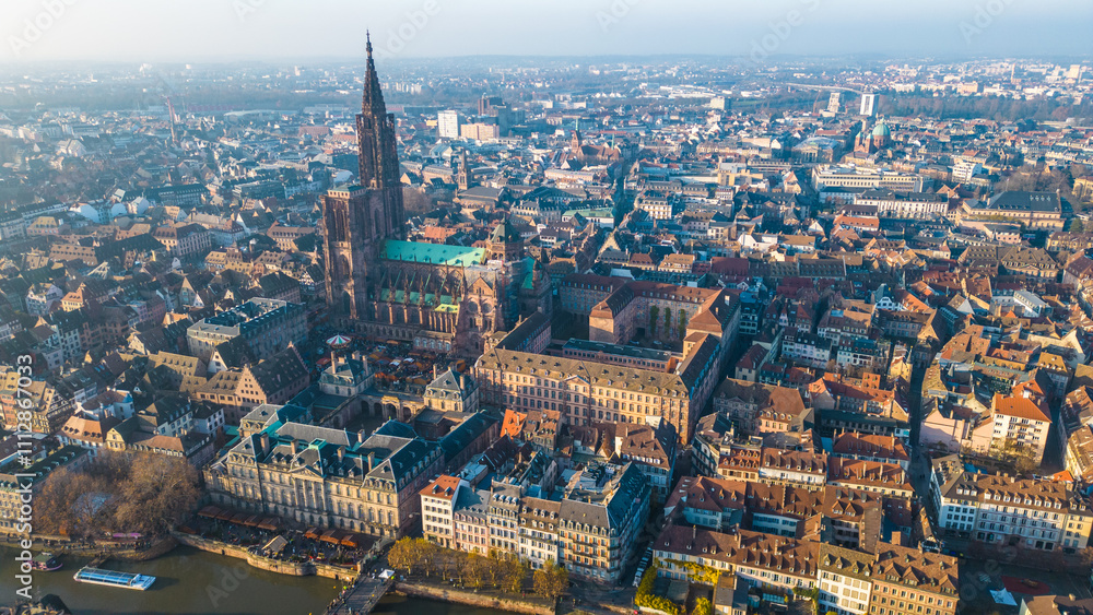 Fototapeta premium Strasbourg, the capital of Christmas, sparkles during Advent, with its stunning decorations and festive ambiance. This aerial view features the majestic Strasbourg Cathedral, La Petite France 