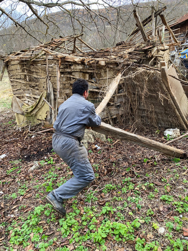 A man demolishes a pig pen. photo