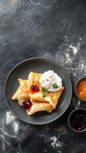 Delicious homemade pancakes served with berry jam and whipped cream on a slee...