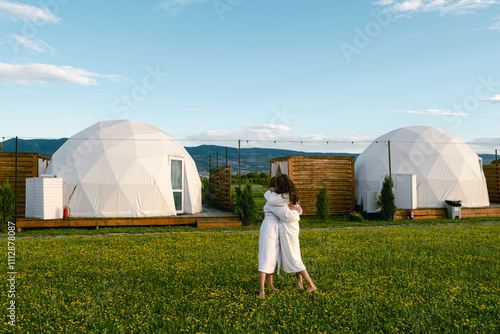 Two women stand in front of a geodesic dome photo