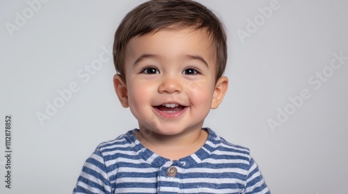 A smiling baby boy in a blue and white striped shirt