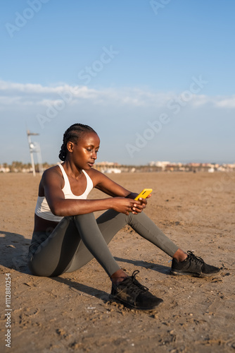 Woman using smartphone at beach photo