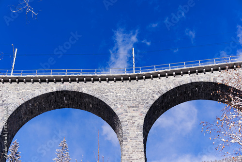 Scenic view of railway viaduct named Schmittentobel at Albula Valley in the Swiss Alps on a sunny autumn day. Photo taken November 22nd, 2024, Schmitten Albula, Switzerland. photo