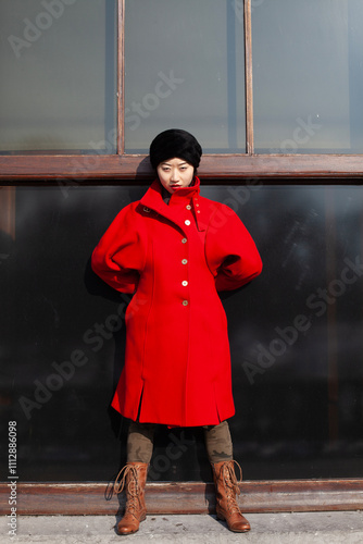 young chinese woman in red coat in front of window photo