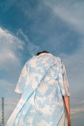  Person in Cloud-Patterned Coat Looking at Sky photo