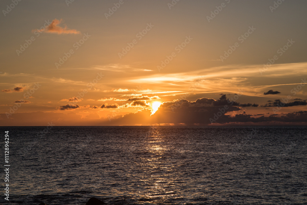 Fototapeta premium Tramonto sul mare con sole e nuvole 