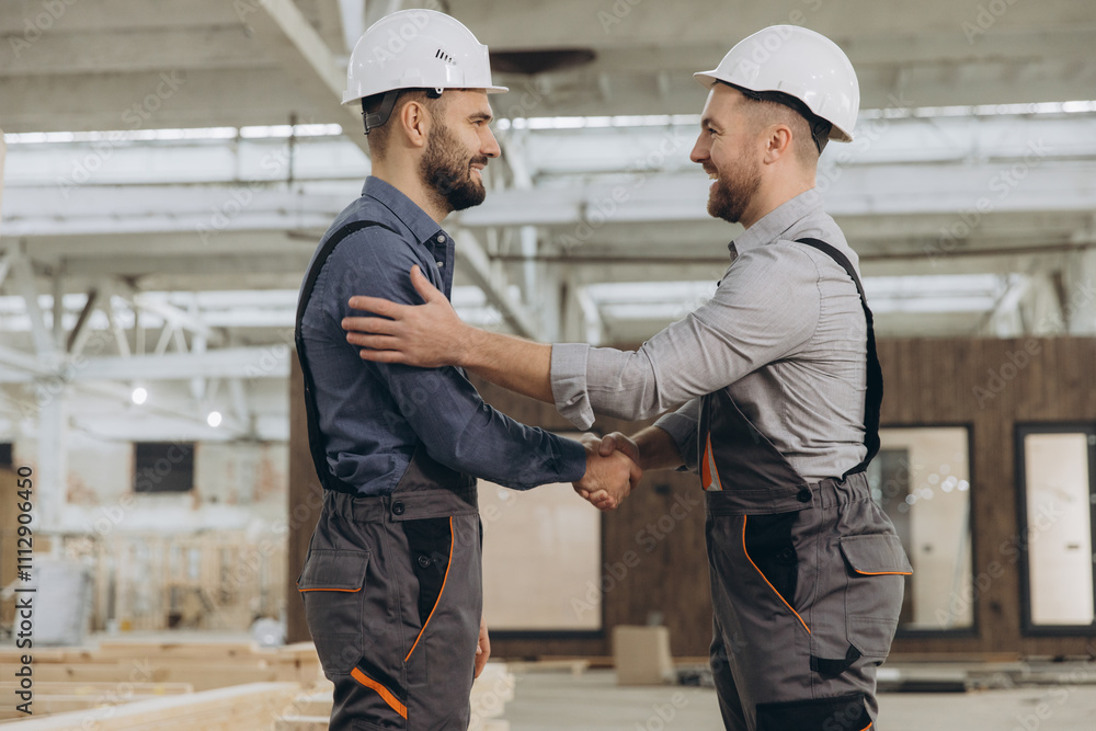 Construction workers shaking hands in modular building industry Construction workers shaking hands in modular building industry