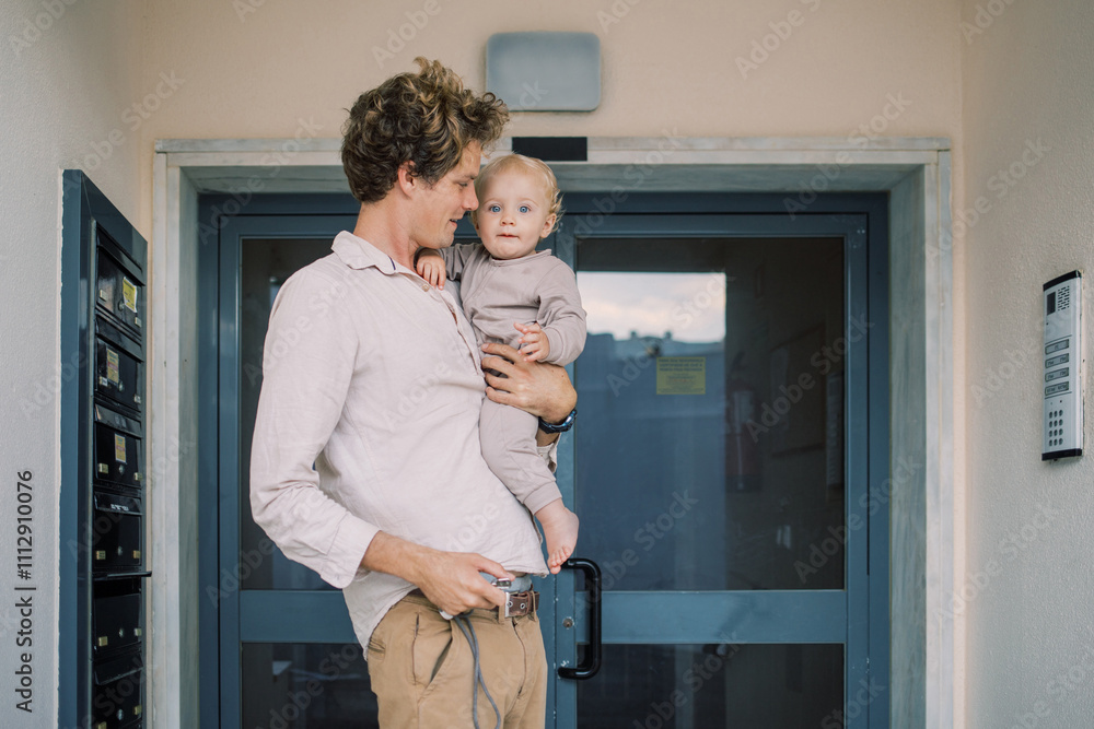 Father and baby near building entrance Father and baby near building entrance