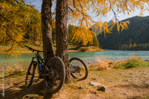 Two bicycles near the  lake in Swiss Alps surrounded by autumn forest 