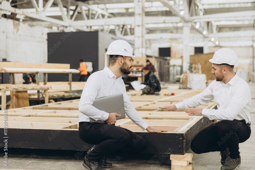 Engineers discussing modular construction process indoors Engineers discussing modular construction process indoors