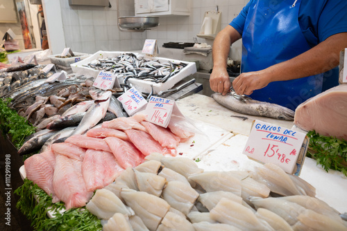 Anonymous fish market vendor cleaning the fish photo