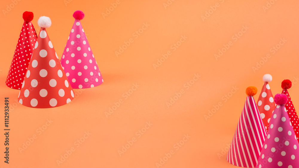 Obraz premium Colorful birthday caps on orange background.