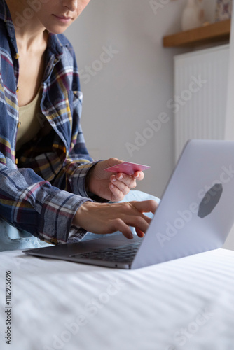 Young woman using credit card and laptop for online shopping at home photo