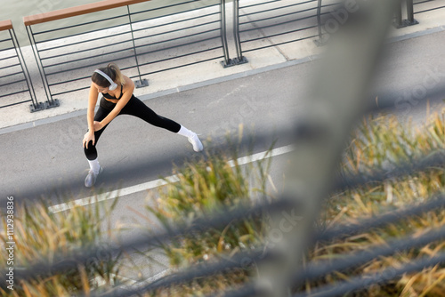 A young woman stretches her...