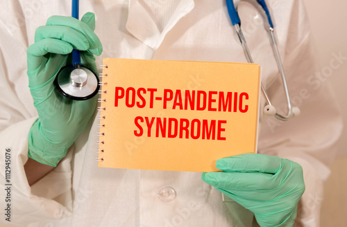 Post-covid syndrome symbol. Hand in blue glove, white card with words 'post-covid syndrome'. photo