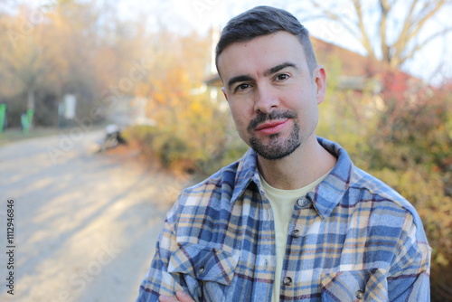 Foto Confident Man in Plaid Shirt Standing Outdoors in a Park at Sunset