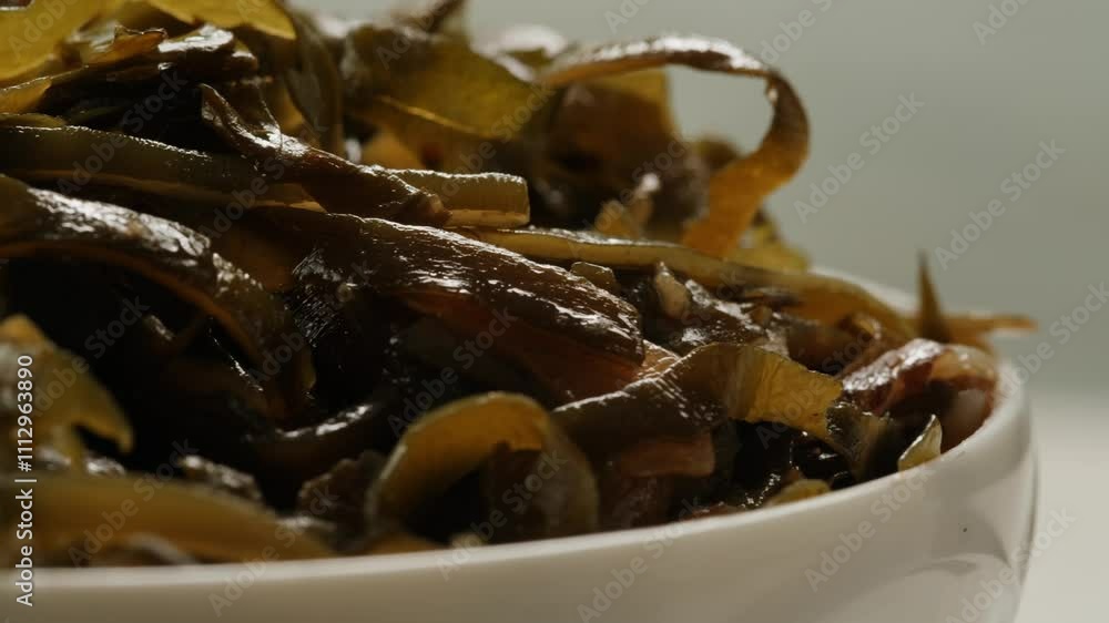 Japanese wakame sea weed laminaria chuka fermented food. Close-up on a detail of Hiyashi Wakame Chuka or seaweed salad or seaweed with sesame seeds on a plate. Top view. Seafood background. Japanese wakame sea weed laminaria chuka fermented food. Close-up on a detail of Hiyashi Wakame Chuka or seaweed salad or seaweed with sesame seeds on a plate. Top view. Seafood background.