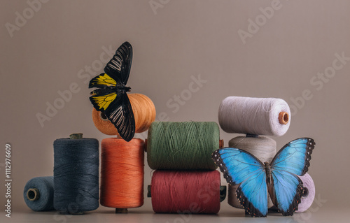 Multicolored spools of thread with a butterfly photo