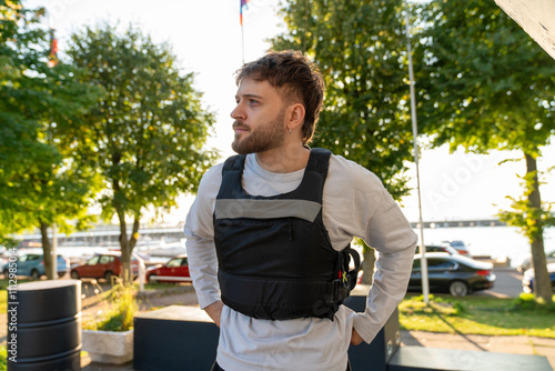 Man wearing life vest outdoors near a waterfront. photo