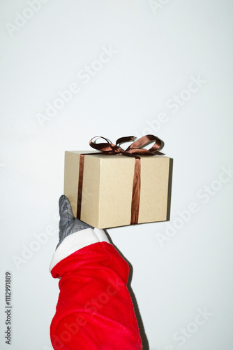 Santa Claus with red coat and glove holding a Christmas present/gift photo