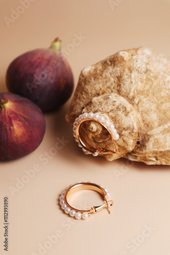 Ring earrings on a textured shell with fresh figs photo