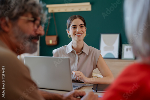 Financial advisor smiling at senior couple during meeting at home