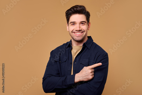 Vászonkép A Cheerful Smiling Man is Confidently Pointing Against a Vibrant and Warm Backgr