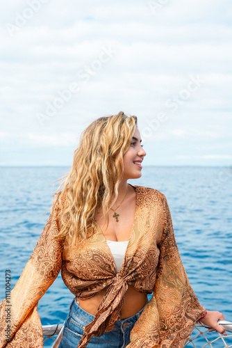 One young blonde and beautiful young woman looking and enjoying summer days in vacation holiday having fun in catamaran boat sailing in the water of sea. photo