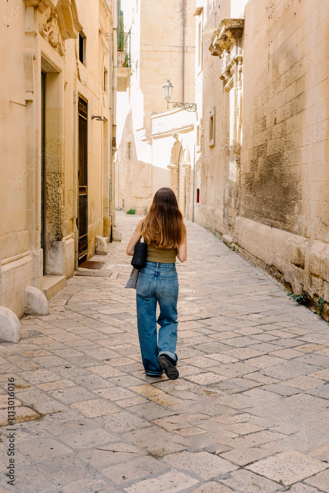 Female traveler strolls in the rustic alleys of Lecce city in Apulia Female traveler strolls in the rustic alleys of Lecce city in Apulia