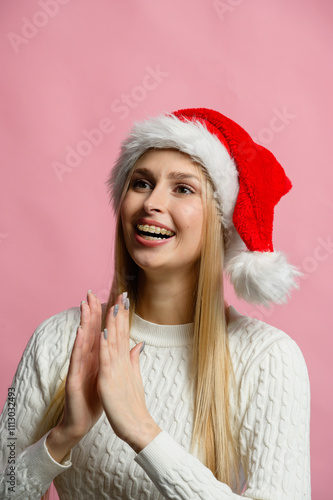 Young woman celebrating Christmas with a joyful expression and festive hat