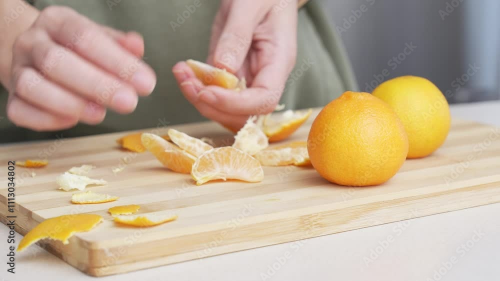 Hands peeling of orange tangerines on the cutting board on table, lots of juicy fresh fruits for cooking on Christmas Hands peeling of orange tangerines on the cutting board on table, lots of juicy fresh fruits for cooking on Christmas