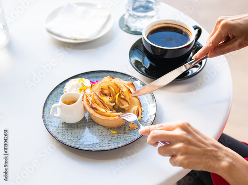 Hands Enjoying Gourmet Apple Rose Tart with Coffee CafÃ© Experie photo