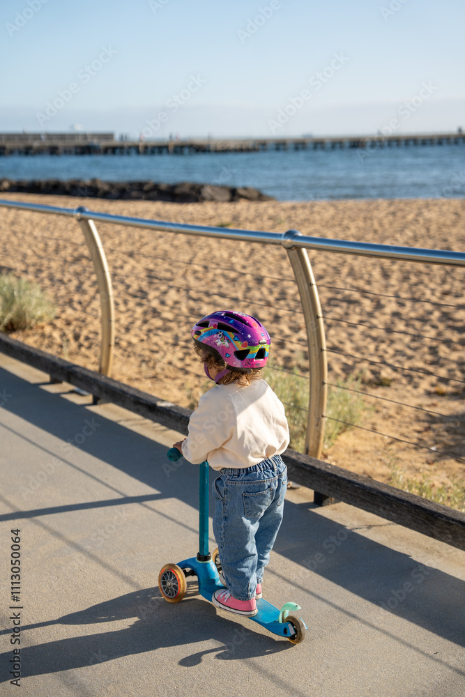A toddler doing scooter at the beach A toddler doing scooter at the beach