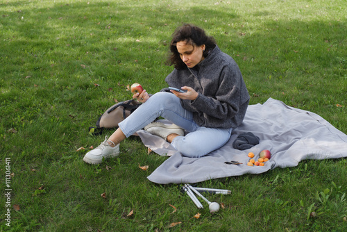 Blind woman enjoying a picnic outside and using smartphone photo